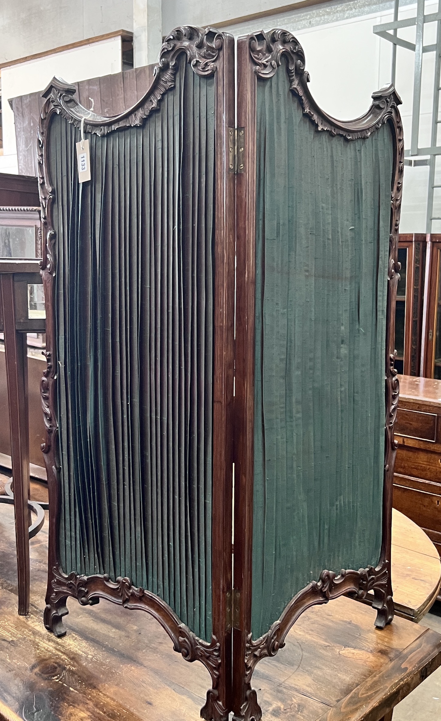 A small Victorian style mahogany two fold carved screen, each panel width 50cm, height 112cm